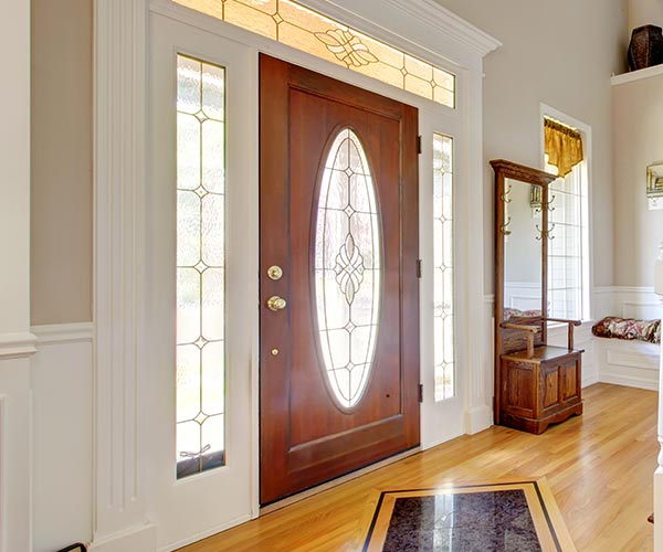 Front Door - A room that has a clock at the top of a wooden door - Staircases